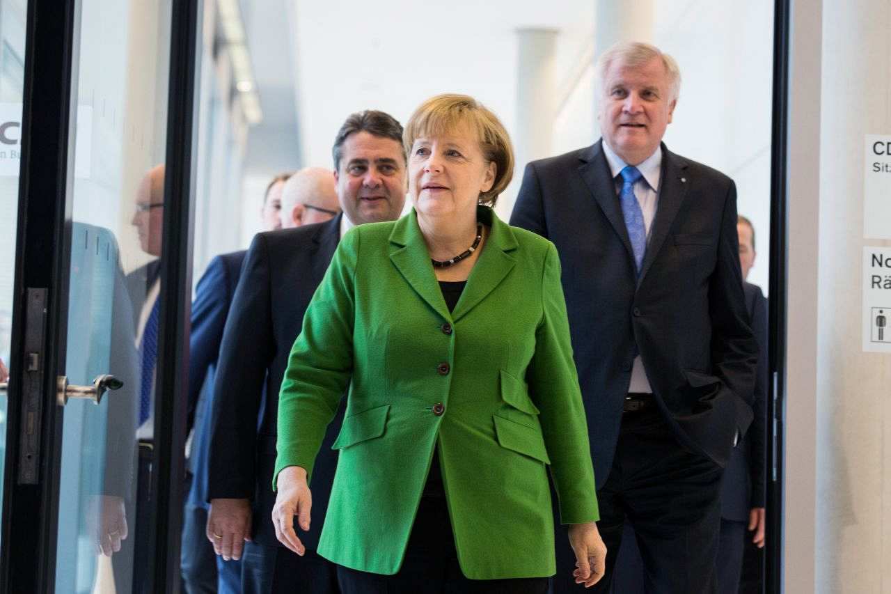 Farbige Abbildung: Bundeskanzlerin Merkel mittig, links hinter ihr Sigmar Gabriel, rechts hinter ihr Horst Seehofer.