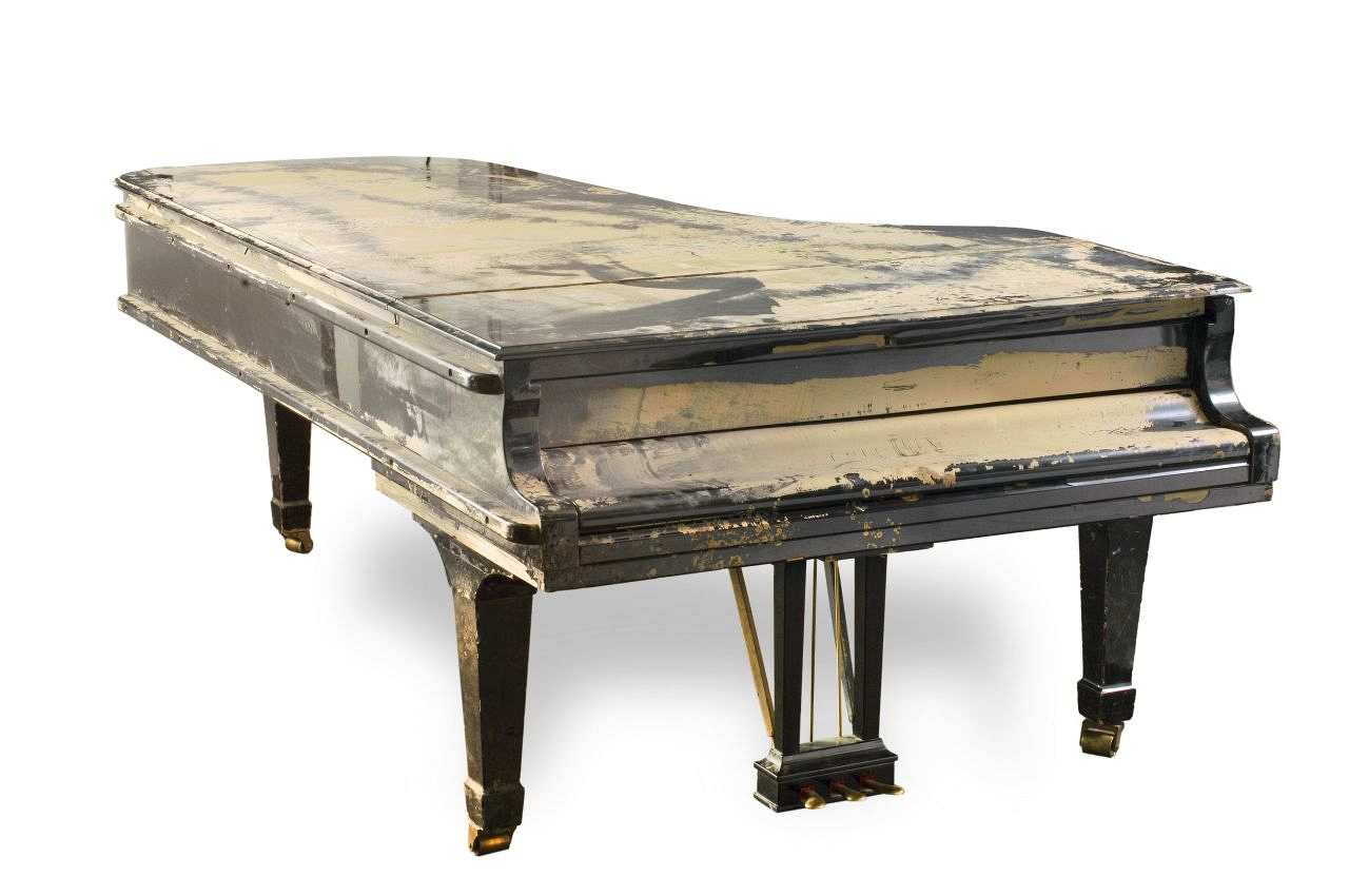 Schwarzer Konzertflügel auf messingfarbenen Rollen. Drei Pedale, goldfarbene Beschriftung auf der Unterseite der Tastaturabdeckung: Steinway & Sons. Oberseite innen links: 489540, rechts: Steinway. Zusätzlich erhabenes ovales Firmensymbol: Steinway & Sons / New York Hamburg.