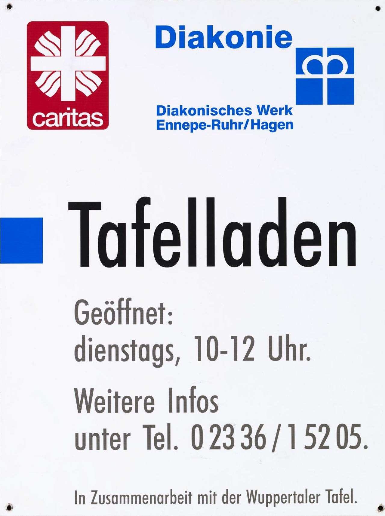 Weiß, oben links rotes Logo der Cariats und rechts blaues Logo der Diakonie, darunter blaue Schrift: Diakonisches Werk Ennepe-Ruhr Hagen, darunter schwarze Schrift: Tafelladen, Geöffnet: Dienstags, 10 - 12 Uhr, Weitere Infos unter Tel. 02336/15205, In Zusammenarbeit mit der Wuppertaler Tafel. Mit vier Befestigungslöchern. 