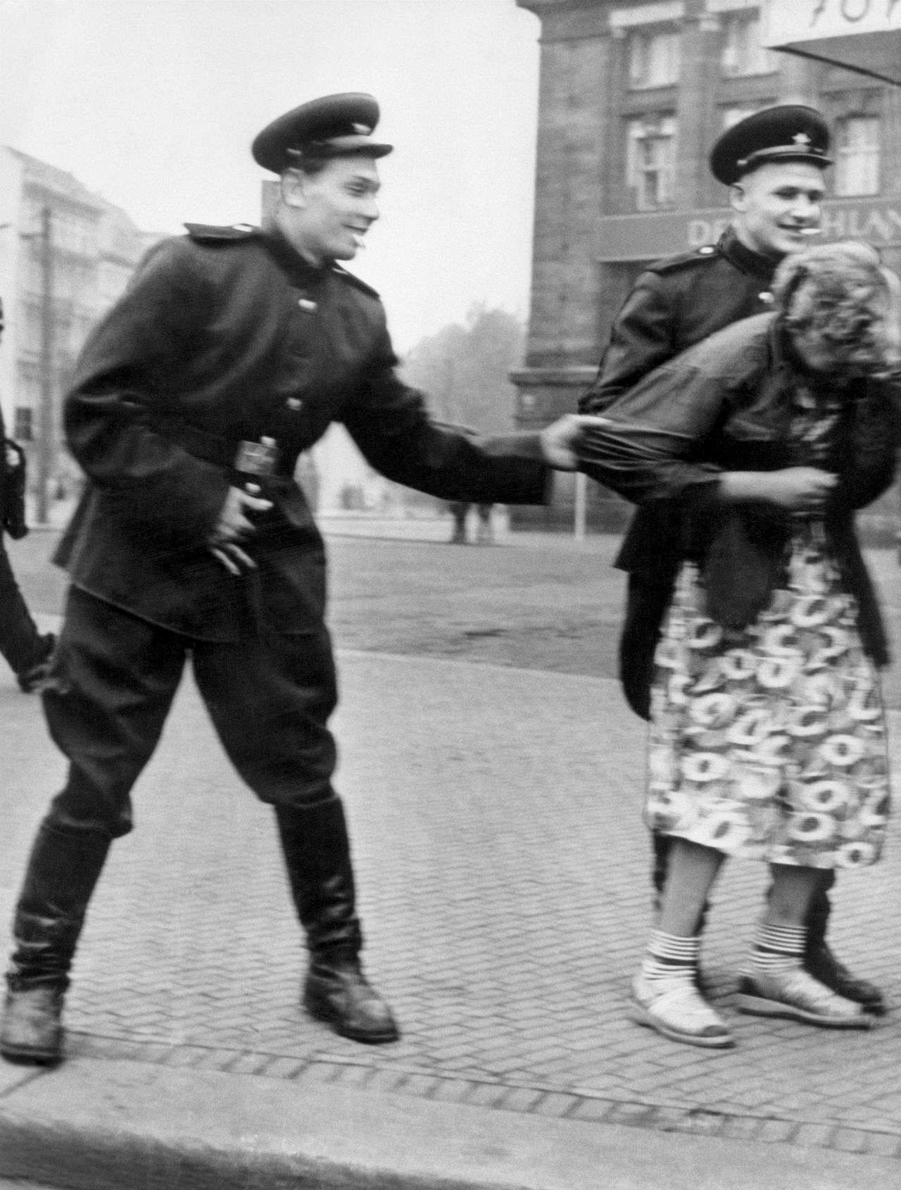 Soldaten der Roten Armee belästigen eine Frau.