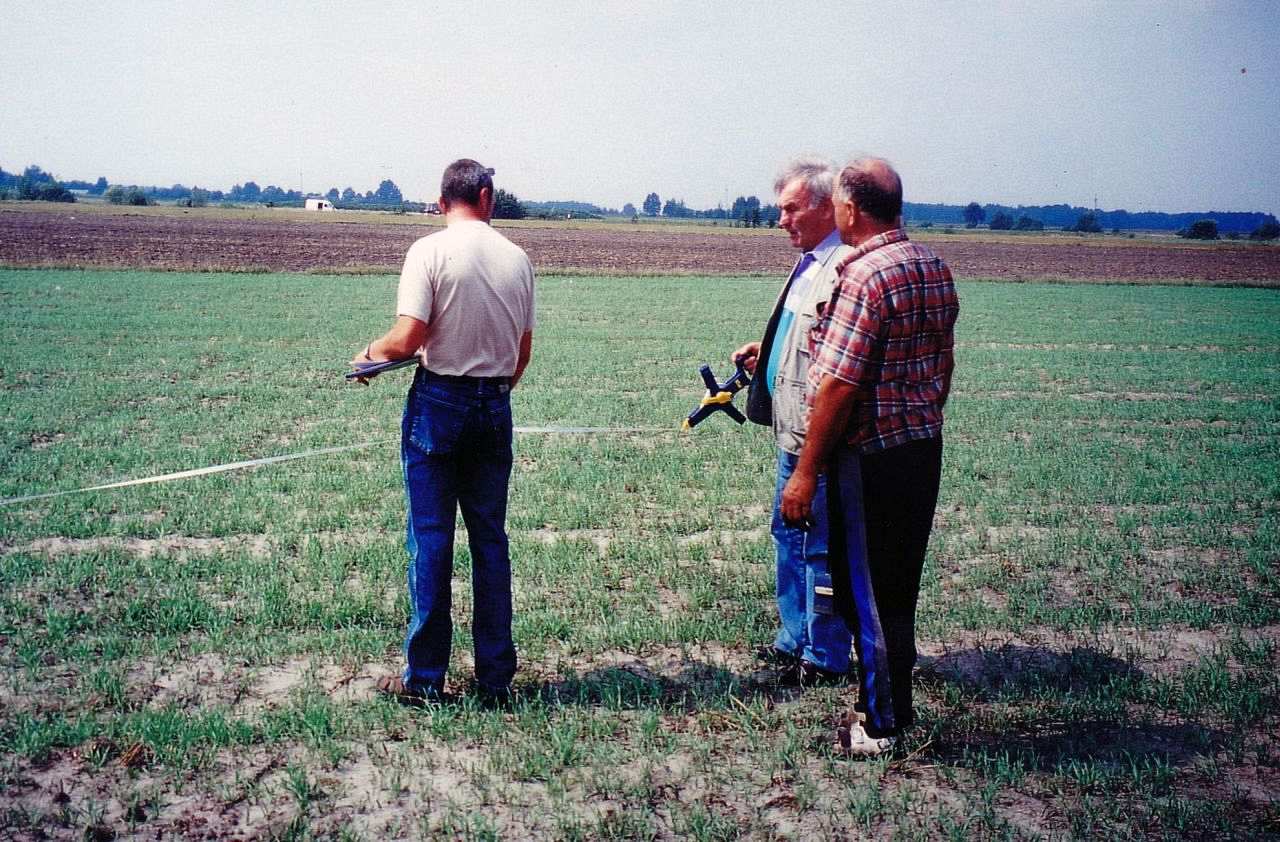 Vermessungsarbeiten auf einem Feld auf der Suche nach dem Soldatengrab des Vaters. Im Hintergrund ist das 250-Einwohner-Dorf Karolin in Polen zu sehen. 
