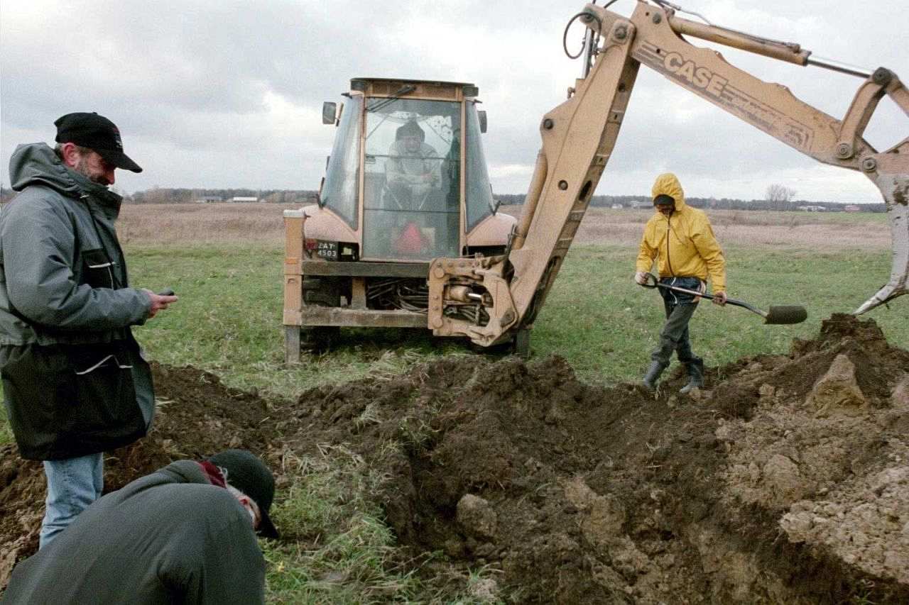 Die Fotografie zeigt den Acker und die Grabungsarbeiten 2002, bei denen Alfred Keffel die Überreste seines Vaters findet, der als Soldat im zweiten Weltkrieg gefallen war.
