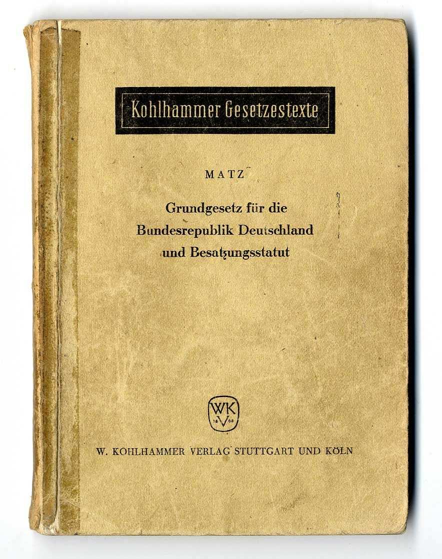 Broschüre mit hellbraunem Einband. Auf der Vorderseite die Beschriftung: Kohlhammer Gesetzestexte Grundgesetz für die Bundesrepublik Deutschland und Besatzungsstatut. Unten die Verlagsbezeichnung.