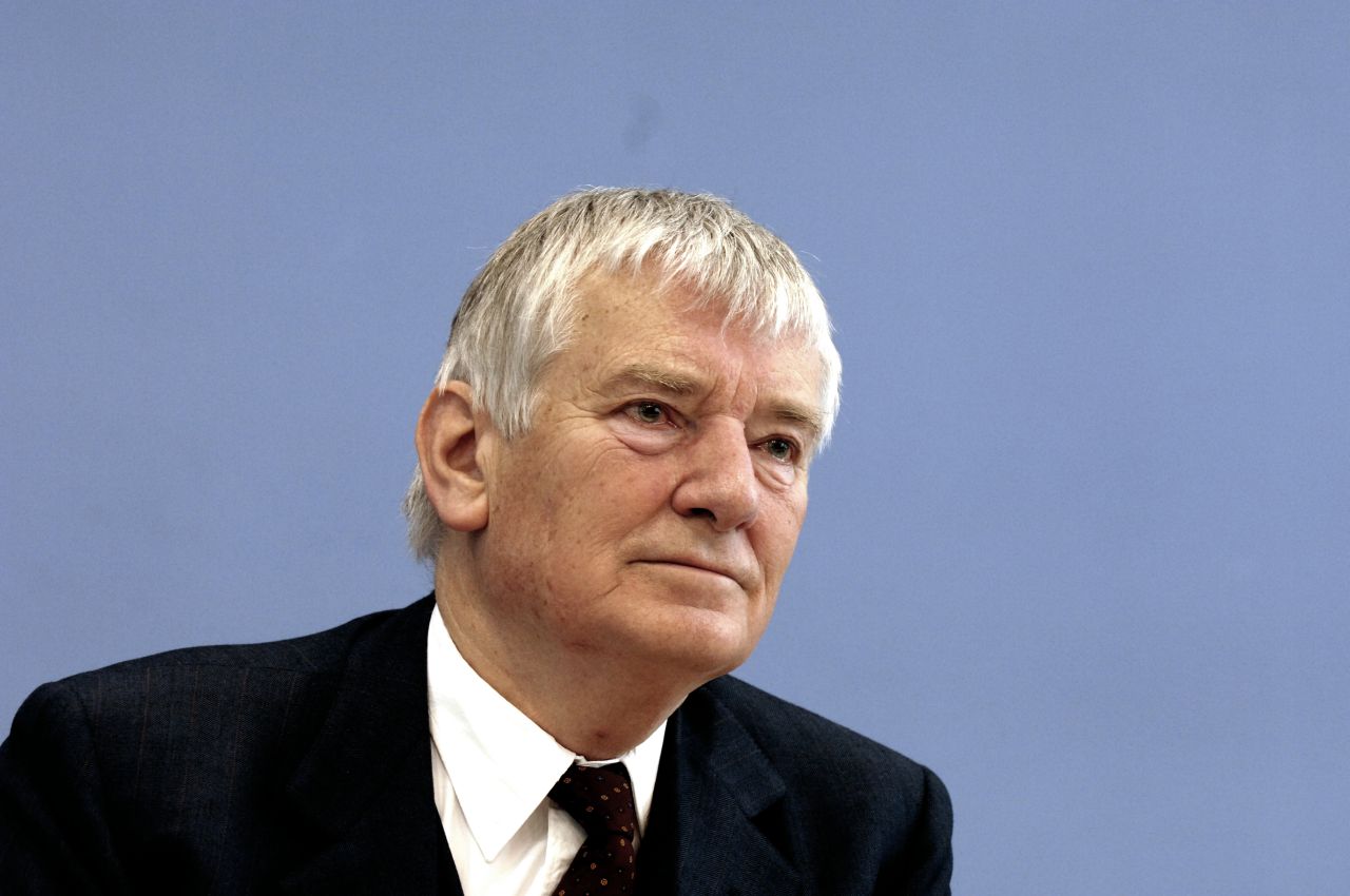 Otto Schily, Bundesminister des Innern im Jahr 2005, vor blauem Hintergrund.