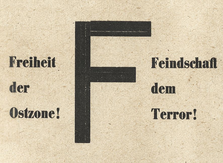 Braunes Blatt, schwarze Beschriftung, in der Mitte Großbuchstabe F, rechts und links daneben: Freiheit der Ostzone! sowie Feindschaft dem Terror!