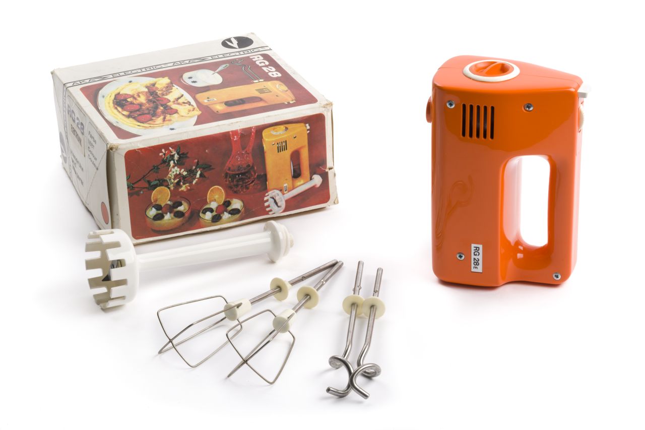Handrühr- und Mixgerät RG 28 bestehend aus orangefarbenem Kunstoffkorpus mit weißer Taste und Hebel, dazu zwei einsteckbaren Schlagbesen sowie zwei Knethaken und einem aufschraubbaren Mixstab