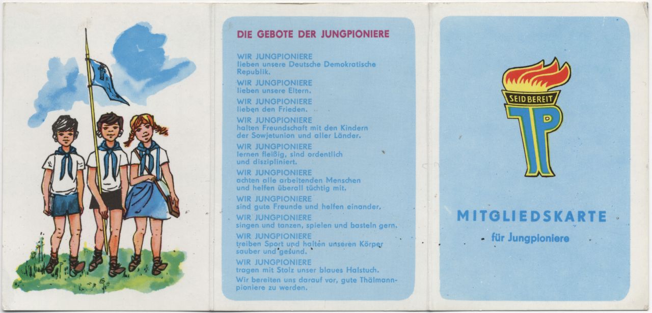 Außenseite eines Ausweises, farbig; 3 Teile durch 2 Falzen; links: Abbildung einer Gruppe von 3 Jungpionieren; mittig Text: 'Die Gebote der Jungpioniere …'; rechts Emblem der Jungpioniere, darunter Text: 'Mitgliedskarte für Jungpioniere'.