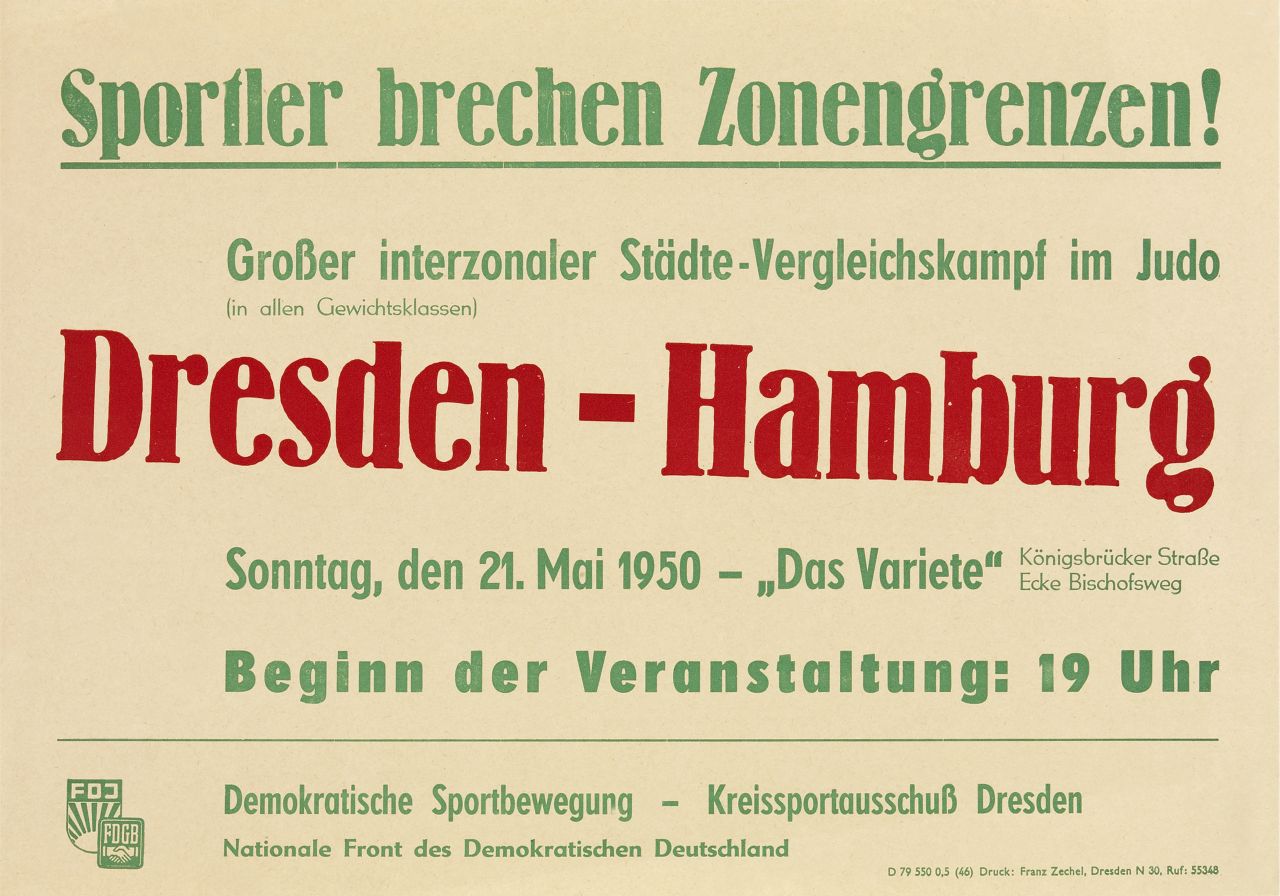 Plakat im Querformat DIN A3, grün/rot bedruckt auf eierschalenfarbenem HG; grün unterstrichen beschriftet: Sportler brechen Zonengrenzen!, anschließend: Großer interzonaler Städte-Vergleichskampf im Judo (in allen Gewichtsklassen), rot beschriftet: Dresden - Hamburg, anschließend Angaben zum Veranstaltungsort und Veranstaltungsbeginn, nach dünnem grünen Trennstrich die Symbole für FDJ und FDGB sowie Beschriftung: Demokratische Sportbewegung - Kreissportausschuß Dresden  Nationale Front des Demokratischen Deutschland.