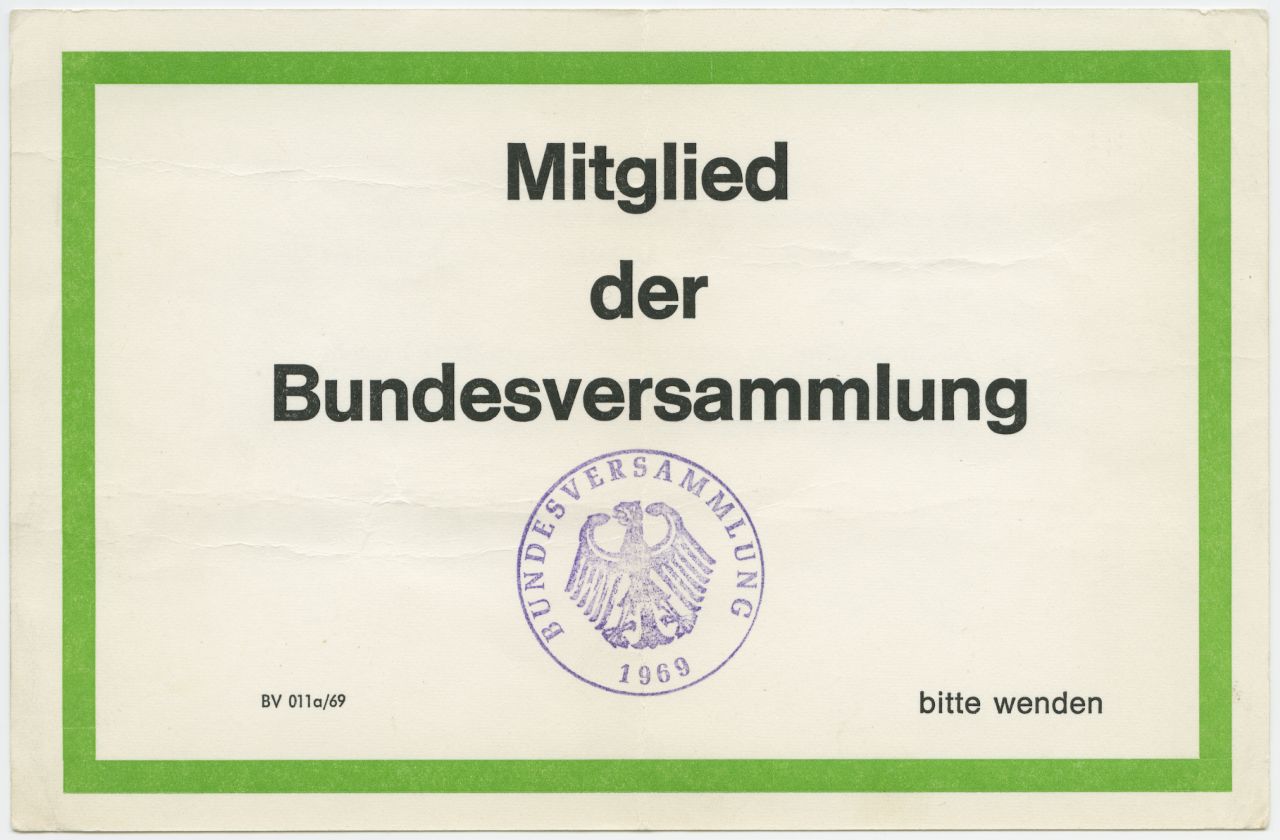 Einseitig beschrifteter und beklebter Papierbogen; oben: 'Bundespräsident Heinemann (1969 - 1974)'; darunter: schwarzer Strich; darunter, aufgeklebt: Karte mit grünem Rahmen; in der Mitte, in schwarzem Fettdruck: 'Mitglied der Bundesversammlung'; darunter; Stempel mit Bundesadler: 'Bundesversammlung 1969'; darunter: Telegramm an den 'Abg. Richter Knackenberg 6 / Wertheim'; Text: 'Hiermit weisen wir noch einmal sehr eindringlich auf die erforderliche Anwesenheit zur Bundesversammlung in Berlin hin. Wir ersuchen dich dringend, so rechtzeitig anzureisen, dass du auf jeden Fall an der Fraktionssitzung am Dienstag dem 4. Maerz um 15.00 Uhr im Reichstag teilnehmen kannst. Falls du noch irgendwelche Hilfen benoetigst, rufe bitte sofort Bonn - Bundeshaus Telefonnr. 162966'; Bogen wird in durchsichtiger Ringbuchhülle aufbewahrt.