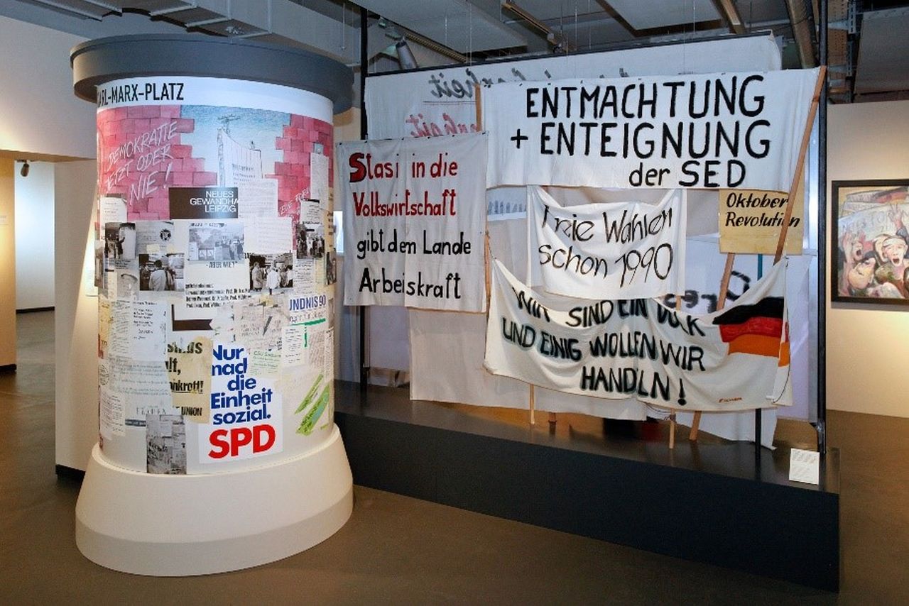 Im Herbst 1989 gehen Tausende Menschen in der DDR auf die Straße, um für Veränderungen einzustehen. Die Transparente von den Montagsdemonstrationen in verschiedenen Städten der DDR machen deutlich, welche Ziele die Demonstranten verfolgen: Sie kämpfen gegen die Macht der SED und der Staatssicherheit, für freie Wahlen, Rechtssicherheit und Demokratie. Ab November mehren sich auch die Forderungen, die Einheit Deutschlands wiederherzustellen.