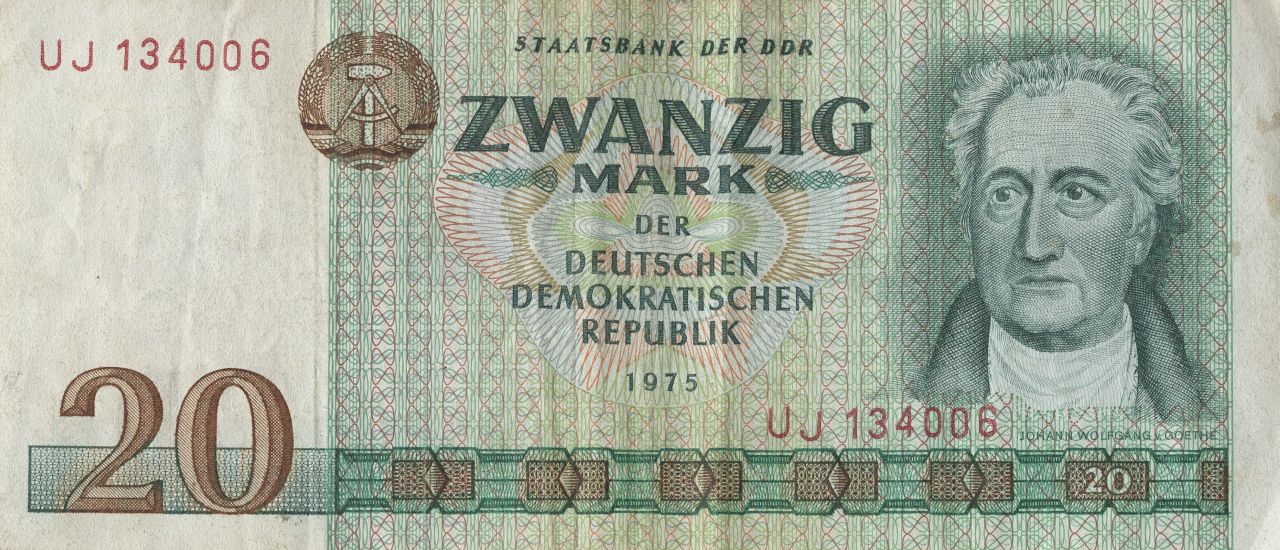 In grün gehaltene Banknote. Links weißes Feld, in dem oben die Nummer des Scheins und unten der Geldwert 20 steht. Mitte: Staatswappen der DDR und der Text:  Staatsbank der DDR/Zwanzig Mark der Deutschen Demokratischen Republik. Rechts: Kopfporträt von Johann Wolfgang v. Goethe.