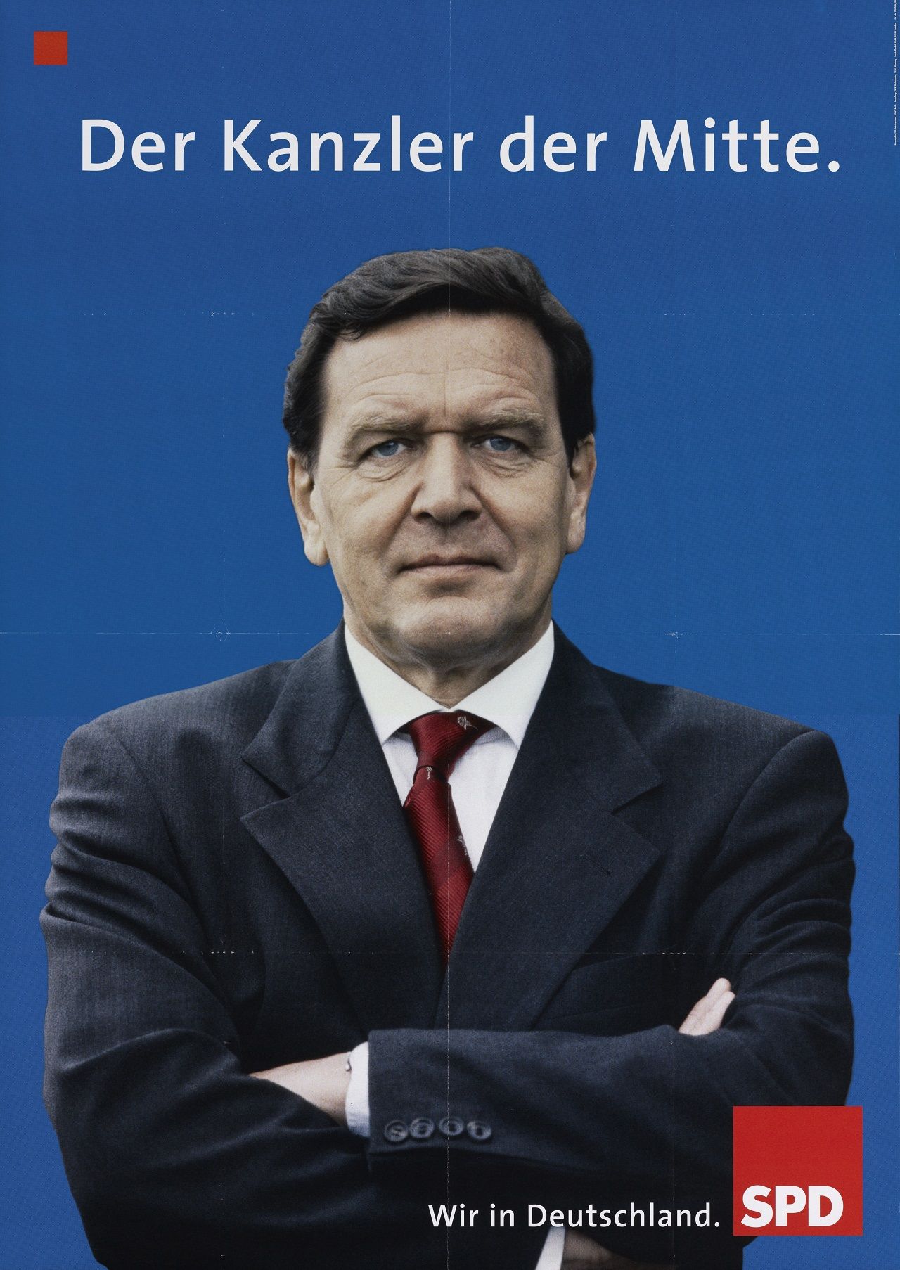 Porträtfoto von Gerhard Schröder mit verschränkten Armen vor blauem Hintergrund. Oben in weiß Bezeichnung, unten rechts: Wir in Deutschland. Rotes SPD-Logo.
