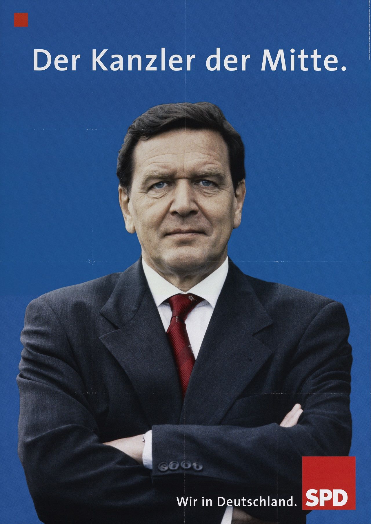 Porträtfoto von Gerhard Schröder mit verschränkten Armen vor blauem Hintergrund. Oben in weiß Bezeichnung, unten rechts: Wir in Deutschland. Rotes SPD-Logo.
